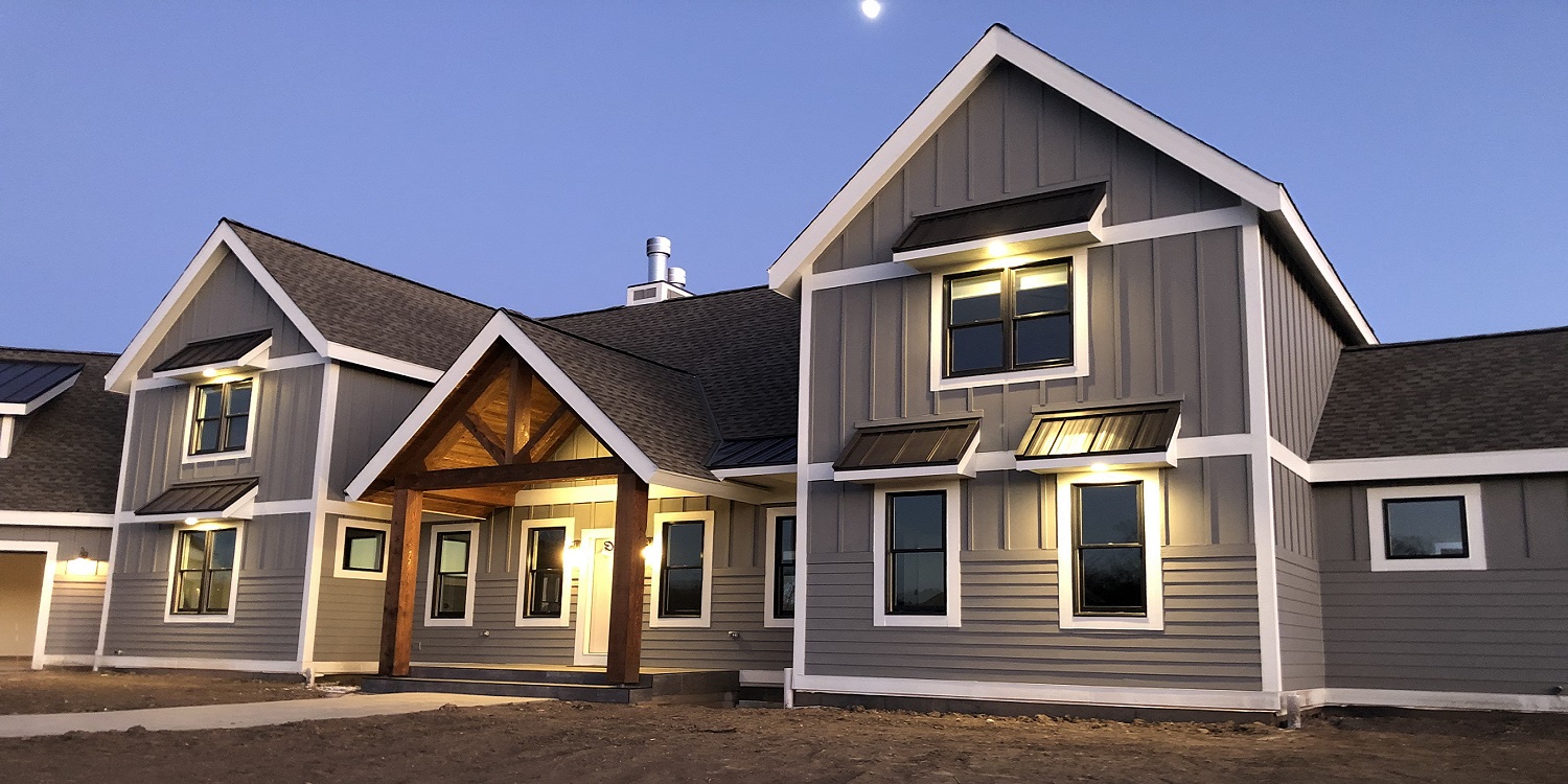 Exterior image of Lueck custom home built by Mikkelson builders.  Modern Farmhouse style , grey with white trim.