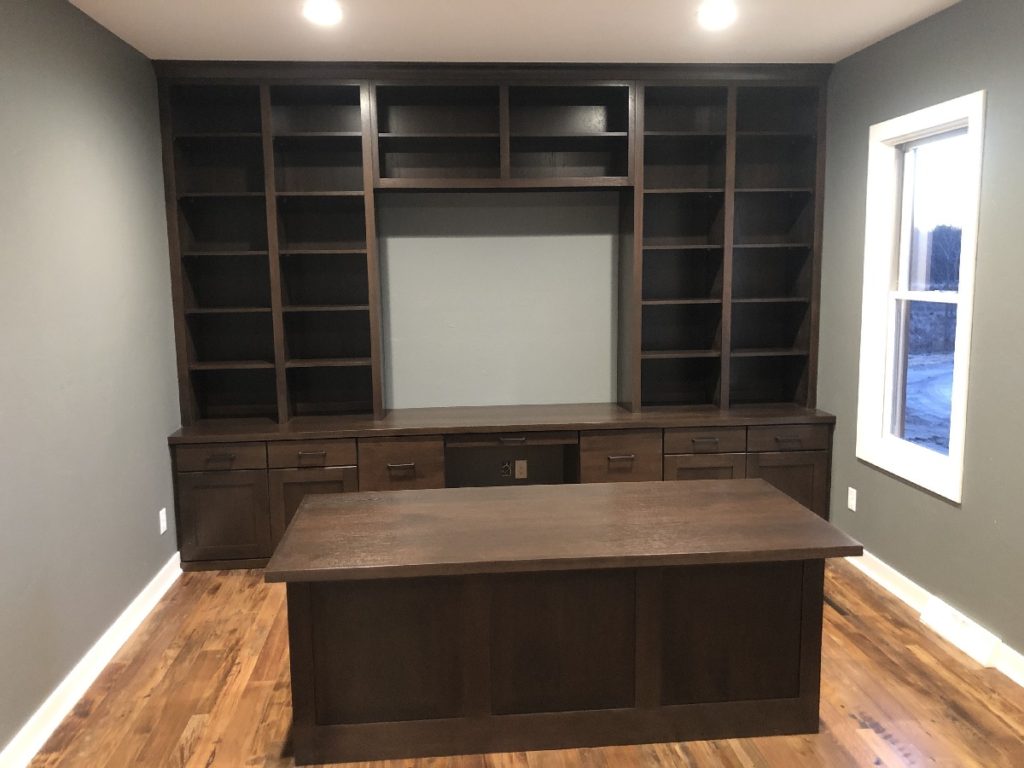 Interior view of office in custom designed home featuring built in custom wall book shelve .storage cabinets and custom desk.