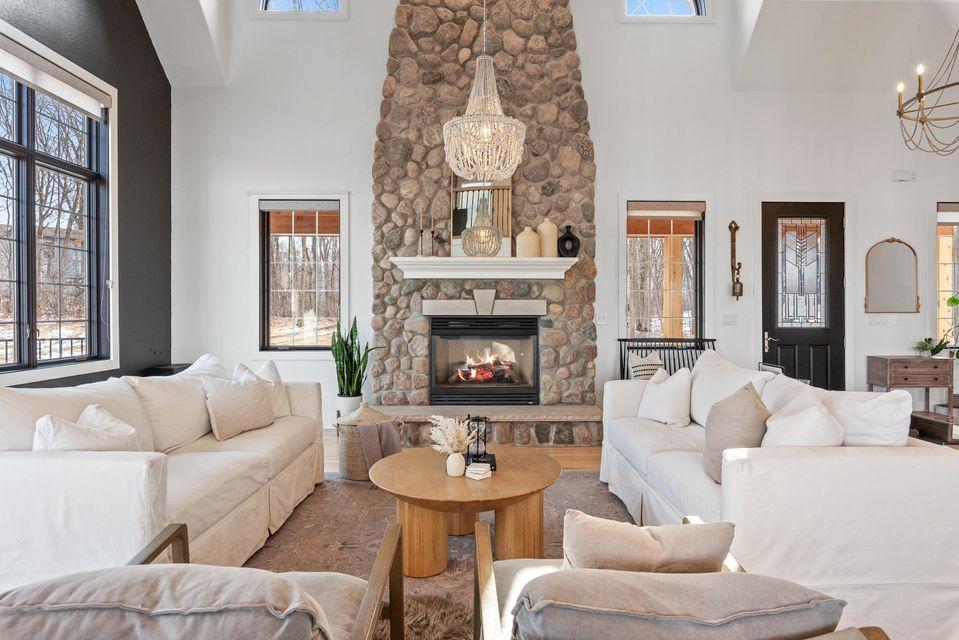 Interior image of Montana custome home featuring stone fireplace, sofas, lighting and table.