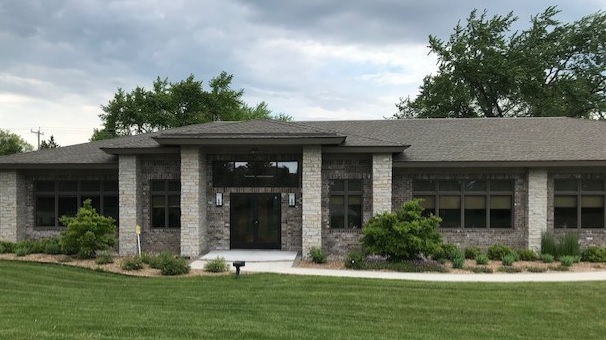 Image of commercial building designed and built by mikkelson builders.  Modern prairie design with stone exterior and slate grey roof.