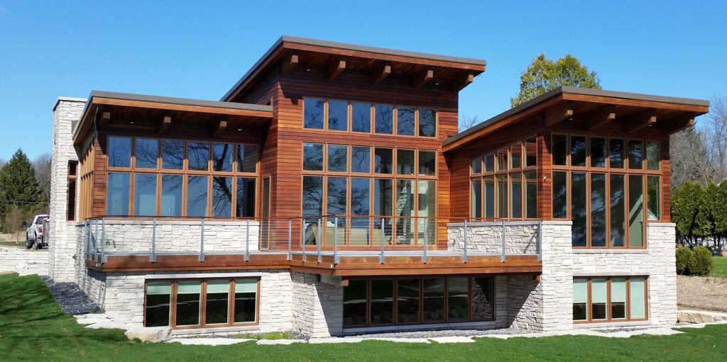 Single story modern prairie style custom home built by Mikkelson builders.  Features wood exterior and large windows throughout.
