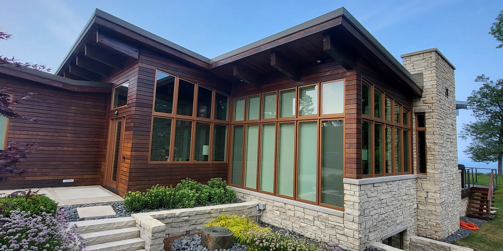 Front view of the butterfly house custom home designed and built by Mikkelson builders.  Modern prairie style featuring slanted roofs and large windows