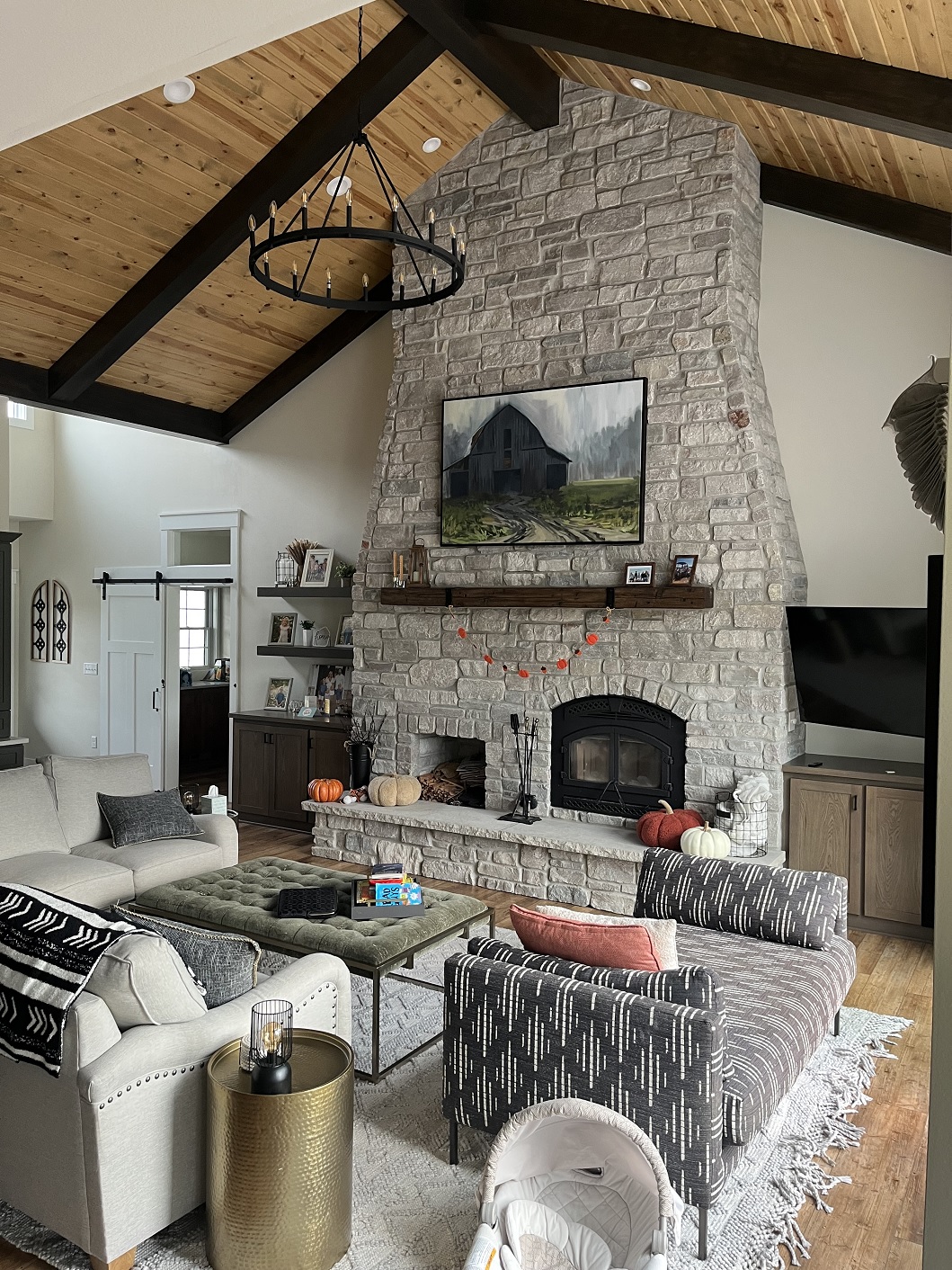 Interior image of fireplace in Kriege custom home.  Floor to ceiling rustic fireplace  built of stone with large wood mantel.